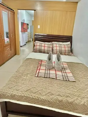 a bed with a pair of shoes sitting on it at MD staycation in Manila