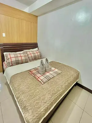 a bed with a pair of shoes sitting on it at MD staycation in Manila