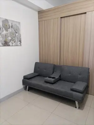 a couch sitting in a room with a painting on the wall at Metro Nest Inn in Manila