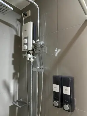 a shower in a bathroom with a phone on the wall at Stunning 41F Skyline View Relaxing City Escape in Manila