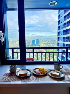 a table with two plates of food in front of a window at Stunning 41F Skyline View Relaxing City Escape in Manila