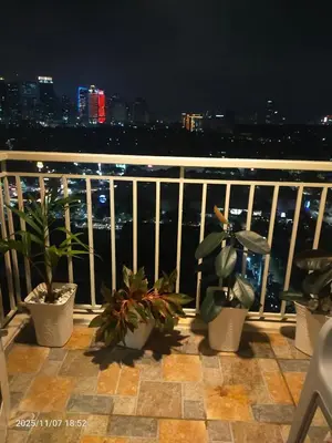 a balcony with potted plants and a view of the city at JC Palace Residences in Manila
