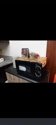 a counter top with a cutting board on top of a microwave at JC Palace Residences in Manila