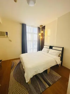 a bedroom with a large white bed with a window at Malate Bayview Mansion City View and Seaview in Manila