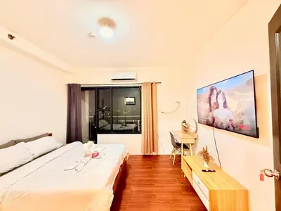 a hotel room with two beds and a desk at Malate Bayview Mansion City View and Seaview in Manila