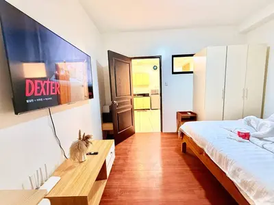 a bedroom with a bed and a tv on the wall at Malate Bayview Mansion City View and Seaview in Manila