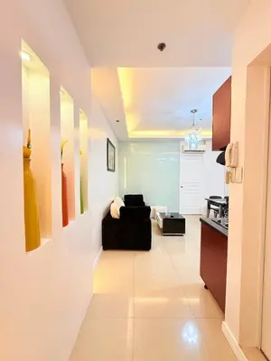 a living room with a black couch in a room at Malate Bayview Mansion City View and Seaview in Manila
