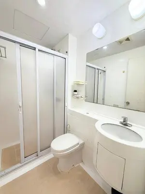 a white bathroom with a toilet and a sink at Malate Bayview Mansion City View and Seaview in Manila