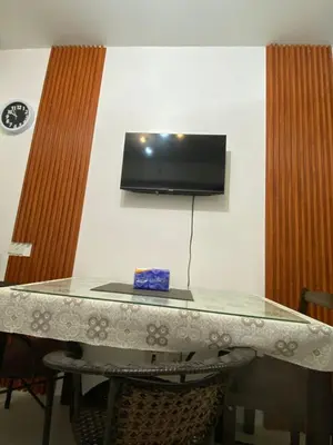 a table with a television on a wall with at Sea Residences Staycation Moa ,Stern Homes in Manila