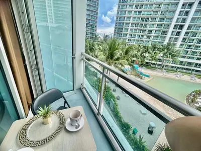 a balcony with a table with a cup of coffee on it at Cozy Condos at Azure Urban Resort in Manila