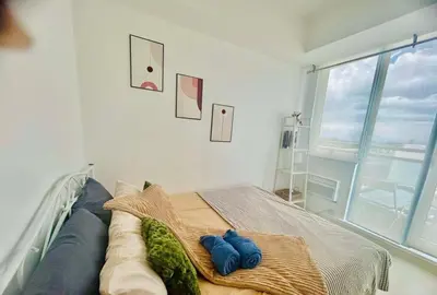 a bedroom with a bed with two blue towels at Cozy Condos at Azure Urban Resort in Manila