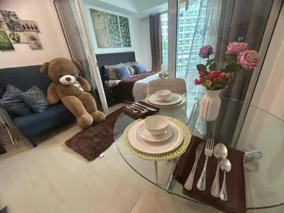 a teddy bear sitting on a couch in a living room at Cozy Condos at Azure Urban Resort in Manila
