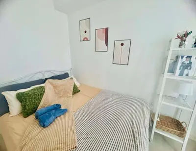 a bedroom with a bed and a white shelf at Cozy Condos at Azure Urban Resort in Manila