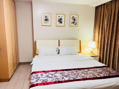 a bedroom with a large white bed with two pillows at Easyworld One Uptown Residence BGC in Manila