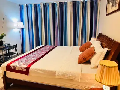 a bedroom with a bed with blue curtains at Easyworld One Uptown Residence BGC in Manila