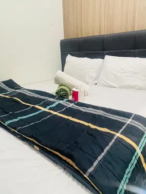 a bed with a blue blanket on top of it at Shore2 Moa ph stay in Manila
