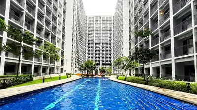 a swimming pool in a city with tall buildings at Shore2 Moa ph stay in Manila