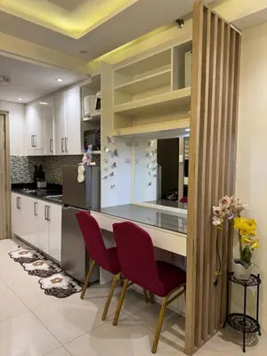 a kitchen with a counter and two red chairs at Shore Homestay in Manila