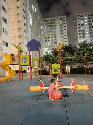 a child playing on a playground in a city at Shore Homestay in Manila