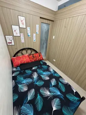 a bedroom with a bed with a blue and white feather bedspread at Shore Homestay in Manila