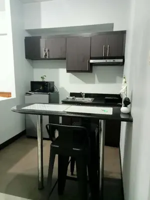 a kitchen with a table with a sink and a stove at Stamford Executive Residence a2 shortwalk Venice Canal mall in Manila
