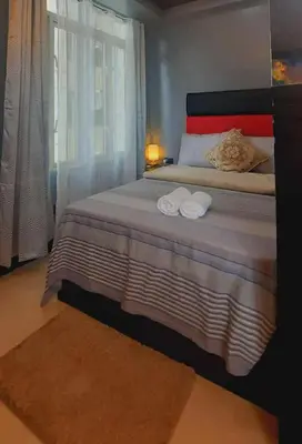 a bedroom with a bed with two towels on it at Stamford Executive Residence a2 shortwalk Venice Canal mall in Manila