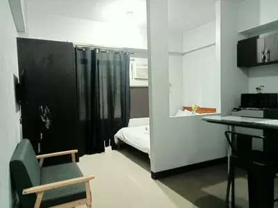 a room with a bedroom with a bed and a desk at Stamford Executive Residence a2 shortwalk Venice Canal mall in Manila