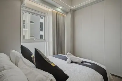 a bedroom with a bed with pillows and a window at Luxury Home near Solaire and Okada Manila in Manila