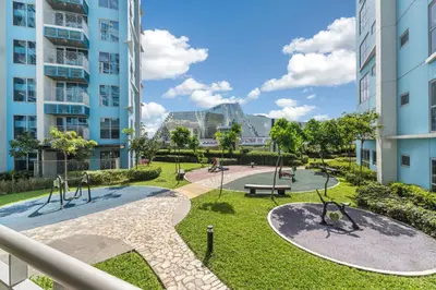 a playground in a park with tall buildings at Luxurious Staycation near Okada, Airport, City of Dreams, Solaire, and MOA with free pool & gym in Manila