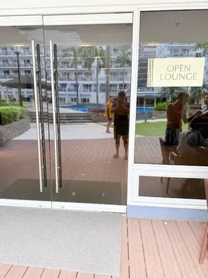 an open lounge sign in a store window at Shell Residences Prime By Paul in Manila