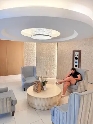 a woman sitting in a chair in a waiting room at Shell Residences Prime By Paul in Manila