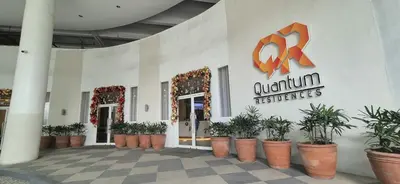 a building with potted plants in front of a store at Quantum Residences in Manila