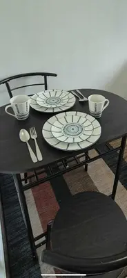 a table with plates and cups and utensils on it at Quantum Residences in Manila