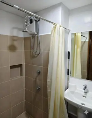 a bathroom with a shower and a sink at Quantum Residences in Manila