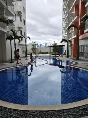 a large blue pool in the middle of a building at Quantum Residences in Manila
