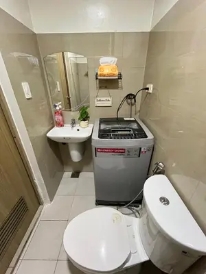 a small bathroom with a toilet and a sink at Athara Suites 2 in Manila