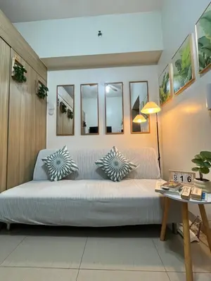 a living room with a large bed with pillows on it at Athara Suites 2 in Manila