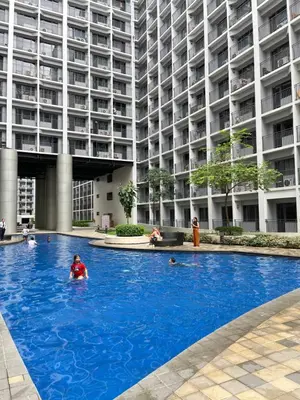 a swimming pool in front of a large building at Athara Suites 2 in Manila