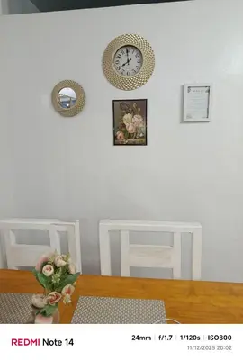 a room with a table and a clock on the wall at Chic Haven Home away from home in Imus