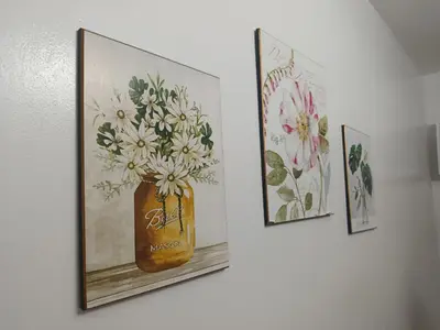 three pictures of flowers in a vase on a wall at Chic Haven Home away from home in Imus
