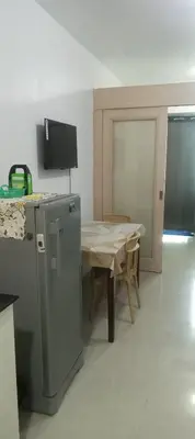 a kitchen with a table and a small refrigerator at Sea Residence 2026 in Manila