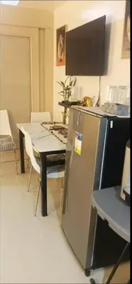 a kitchen with a table and a table and a refrigerator at Sea Residence 2026 in Manila