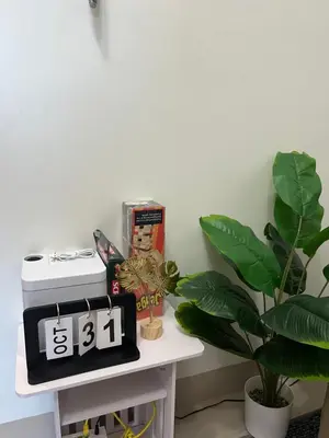 a clock sitting on a table next to a plant at 3Ms Homestay Shore in Manila