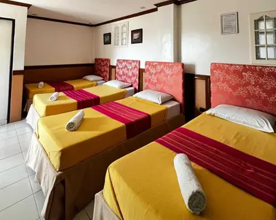 a group of four beds in a room at Palette Gems Hotel and Conference Center in Quezon City