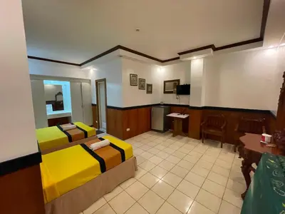 a hotel room with two beds and a television at Palette Gems Hotel and Conference Center in Quezon City