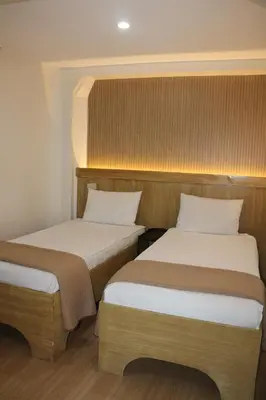 two beds in a small room with at Stone House Hotel Manila in Manila