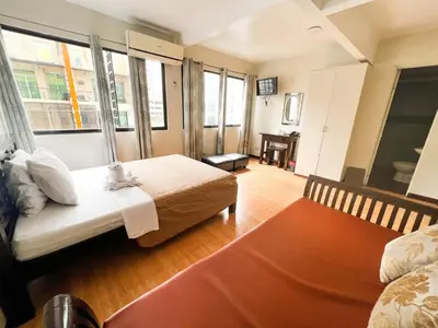 a hotel room with a bed and a window at Stone House Hotel Manila in Manila