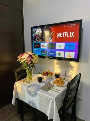 a table with a plate of food and a tv at Air Residences 49F City View, Wifi & Netflix in Manila