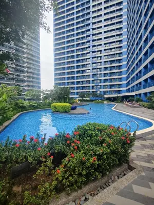 a large swimming pool in front of tall buildings at Air Residences 49F City View, Wifi & Netflix in Manila