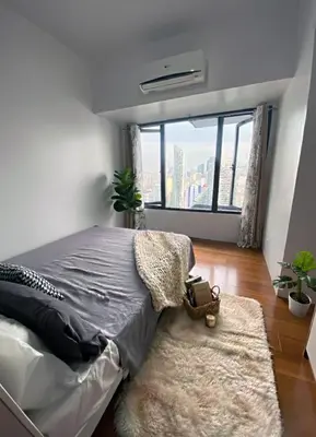 a bedroom with a bed and a large window at Air Residences 49F City View, Wifi & Netflix in Manila